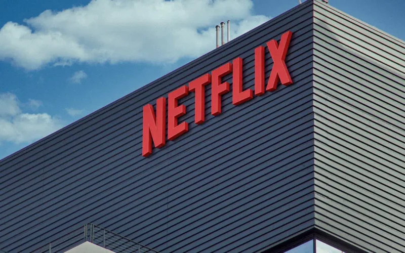 Prédio com o logotipo vermelho da Netflix na fachada, sob céu azul