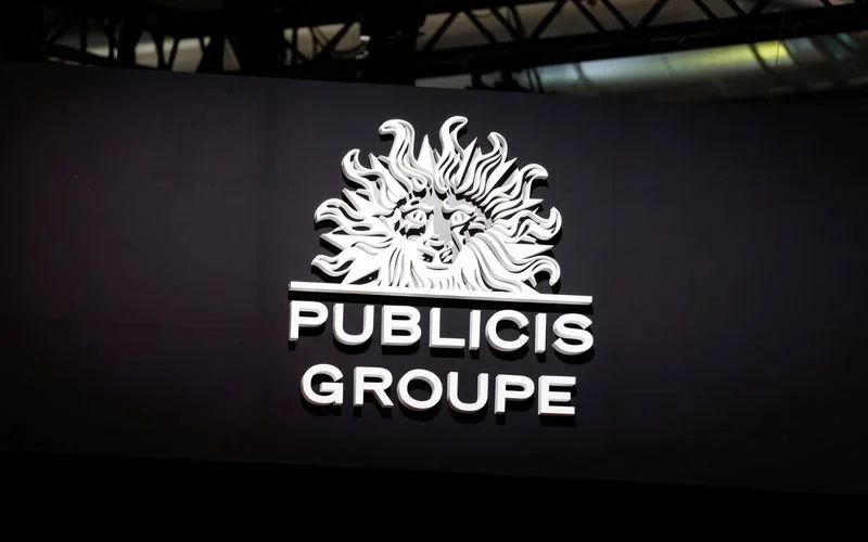 Logotipo do Publicis Groupe em letras brancas sobre uma parede escura em um evento