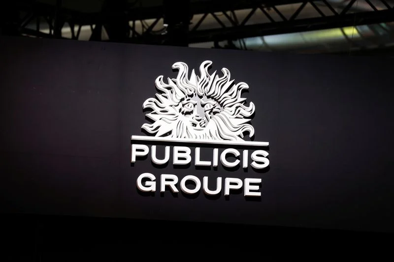 Logotipo do Publicis Groupe em letras brancas sobre uma parede escura em um evento